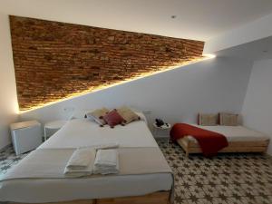 a bedroom with two beds and a brick wall at Hotel Rural Casa Cuartel in San Vicente de Alcántara