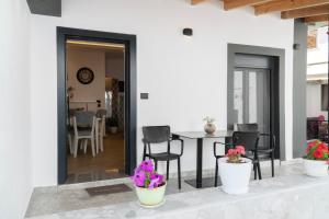 a patio with chairs and a table with purple flowers at Villa Rafail in Ksamil