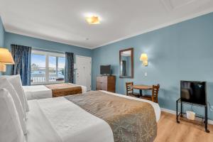 a hotel room with two beds and a television at Surfside Motel in Point Pleasant Beach