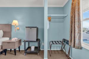 a room with a bed and a chair and a window at Surfside Motel in Point Pleasant Beach