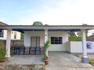 a small white house with a patio at Rembulan Homestay in Mersing