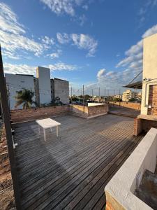 eine Holzterrasse mit einer Bank auf dem Dach eines Gebäudes in der Unterkunft Urban River Hostel in Corrientes