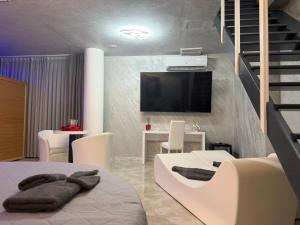 a room with a bed and a tv and a staircase at B&B Luxury Room e Spa in Apricena