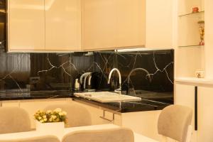 a kitchen with a sink and a black counter top at Villa Rafail in Ksamil +111 photos