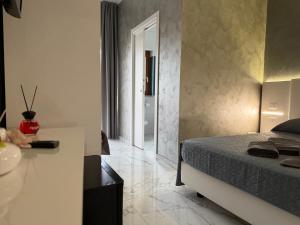 a bedroom with a bed and a bathroom with a sink at B&B Luxury Room e Spa in Apricena