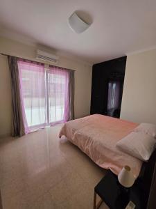 a bedroom with a bed and a large window at Vendome in Paceville