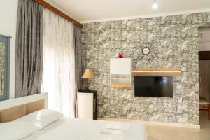 a bedroom with a bed and a stone wall at Villa Rafail in Ksamil