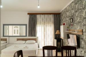 a hotel room with a bed and a table and chairs at Villa Rafail in Ksamil
