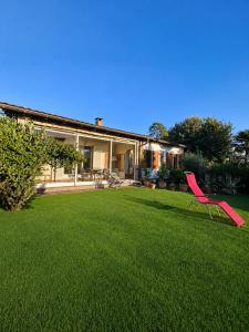 a red chair sitting in the yard of a house at Lake View Palm Garden in Lugano +22 photos