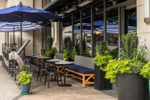 a restaurant with tables and chairs with blue umbrellas at Hotel 1000, In The Unbound Collection By Hyatt in Seattle