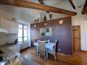 a kitchen with a table and chairs in a room at La Maison du Canal- vue Canal- L'ère du Temps in Homps
