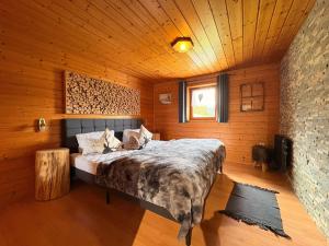 a bedroom with a bed in a wooden room at Alphüsli Garfrescha in Sankt Gallenkirch