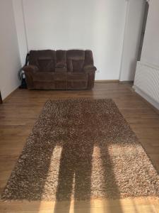 a brown rug in a living room with a couch at Eli house in Târgu Neamț +2 photos