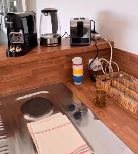 a kitchen counter with a coffee maker and a toaster at Studio les Écuries de la forêt 2 in Le Buisson Genois