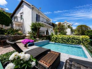 a villa with a swimming pool and a house at Apartments Obradovic in Krašići