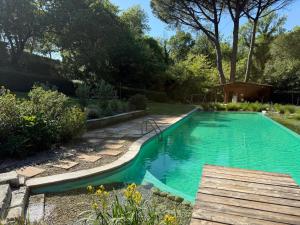 a swimming pool in a garden with a wooden deck at Bioagriturismo il cerreto in Pomarance +63 photos