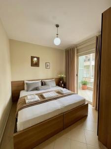 a bedroom with a large bed and a window at Solis Apartments in Vlorë