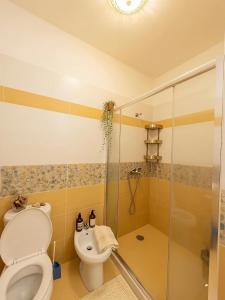 a bathroom with a toilet and a glass shower at Solis Apartments in Vlorë