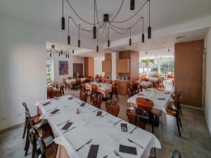 a dining room with tables and chairs and a chandelier at La Regina d'Alabastro in Menfi