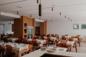 a dining room with white tables and chairs at La Regina d'Alabastro in Menfi +10 photos