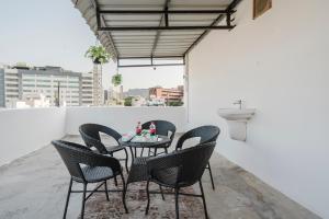 a table and chairs on a balcony with a sink at Innzoy Comforts - Hitech City Hyderabad in Hyderabad