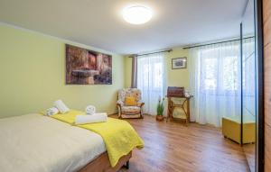 a bedroom with a bed with a yellow blanket and a chair at Apartment Avelina in Mošćenice