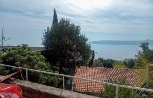 a view of the ocean from a house with a fence at Apartment Avelina in Mošćenice