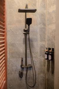 a shower with a hose attached to a wall at Layag La Union in san juan la union +44 photos