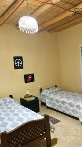 a bedroom with two beds and a chandelier at By Lela in Tinogasta