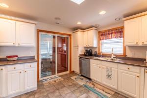 a kitchen with white cabinets and a window at Pelican Watch - Kitty Hawk MP 3, 16 Yards to Beach, Ocean View, Pool, Hot Tub, Pool Table, Flex Stays in Kitty Hawk +51 photos
