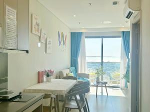 a kitchen and living room with a table and chairs at CĂN HỘ CAO CẤP THE SONG VŨNG TÀU - LUXURY APARTMENT THE SÓNG VŨNG TÀUs in Vung Tau
