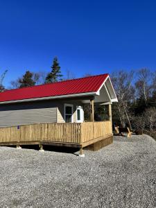 ein großes Gebäude mit einem roten Dach und einer Veranda in der Unterkunft Gros Morne Tiny Chalets in Rocky Harbour + 1 Foto