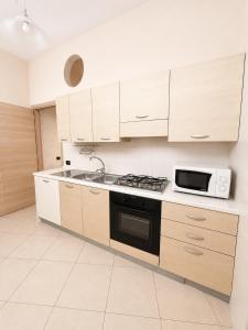 a kitchen with a stove and a microwave at B&B Sud Est in Carmiano