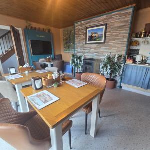 a room with tables and chairs and a fireplace at Salmon island view in Dromineer