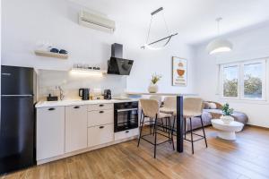 a kitchen with white cabinets and a black refrigerator at Kastri Houses in Panormos Skopelos