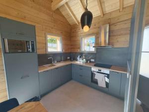 a large kitchen with wooden walls and counters at Le Chalet du Soleil Levant in Longevilles-Mont-dʼOr