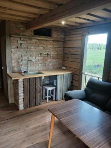 a kitchen in a log cabin with a sink and a table at Arakaoja Puhkemaja in Nepste