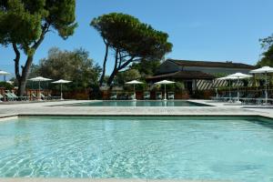 a swimming pool with chairs and umbrellas at Conero Azzurro in Numana