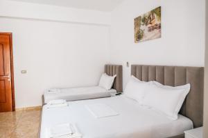 a bedroom with a white bed with white pillows at Vila Malo in Ksamil +102 photos