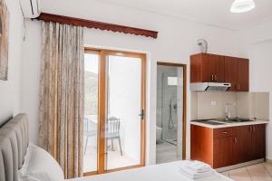 a bedroom with a sliding glass door leading to a bathroom at Vila Malo in Ksamil