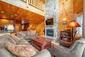 a living room with couches and a stone fireplace at Cedar Shores Villa #08 by Railey Vacations in McHenry