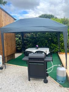 a gazebo with a table and a grill at La Tiny de la chicorée in Paulhan