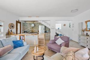 a living room with two couches and a kitchen at Villa Helia in Yénion