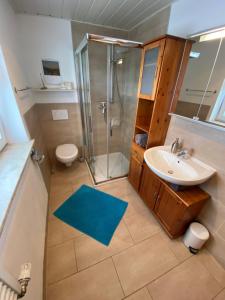 a bathroom with a sink and a shower and a toilet at Ferienwohnung Pickert in Bad Endorf +13 photos