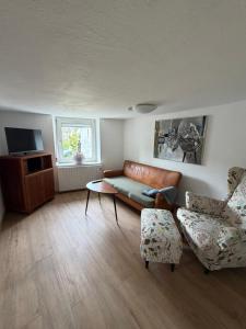 a living room with a couch and two chairs at EifelFein in Niederstadtfeld