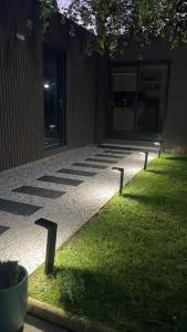 a row of lights on the grass in front of a building at L'Escale d'Omaha - Cottage de 50m2 in Saint-Marcouf