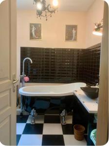 a bathroom with a tub and a sink at Les Glycines-chambre d'hôtes in Chârost