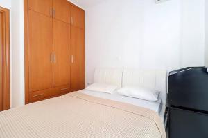 a small bedroom with a bed and a refrigerator at Kai Guest House in Polychrono