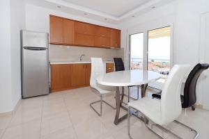 a kitchen with a white table and a refrigerator at Kai Guest House in Polychrono