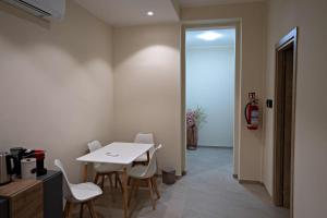 ein Esszimmer mit einem weißen Tisch und Stühlen in der Unterkunft Max's Rooms in Termoli + 10 Fotos